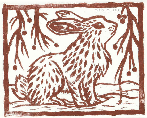 A linocut print of a rabbit sitting in the snow with brambles framing the scene.